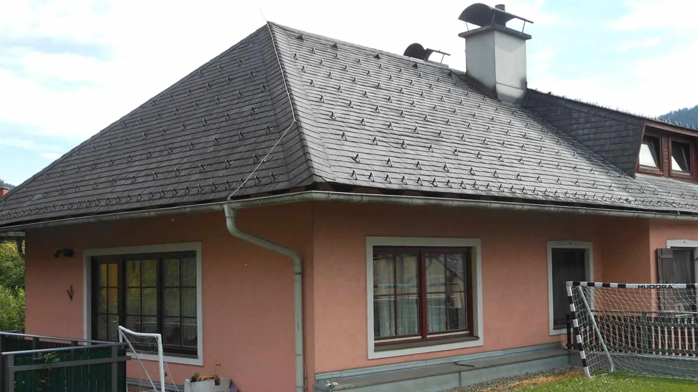 Dach czterospadowy przed modernizacją domu z trapezowym oknem dachowym przy zastosowaniu dachówki PREFA