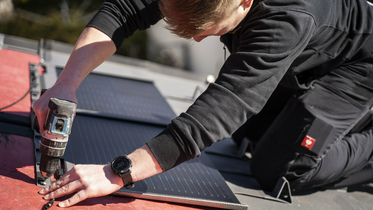 Pracownik PREFA podczas układania dachówki solarnej.