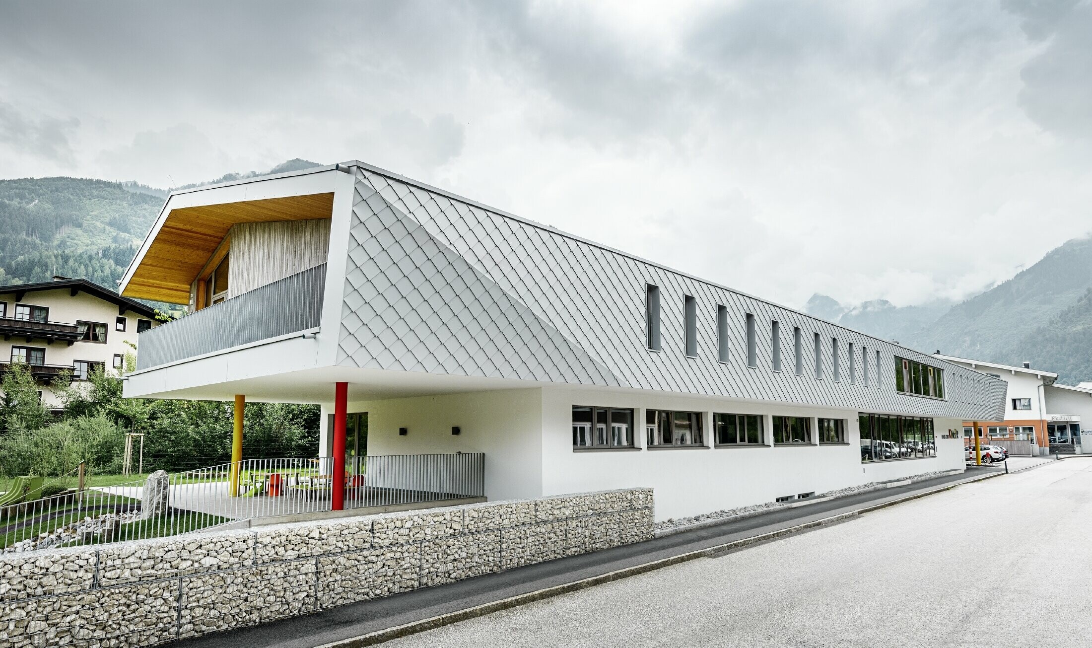 Nowo wybudowane przedszkole w Kaprun z nowoczesną aluminiową elewacją wykonaną z rombu fasadowego PREFA w kolorze bieli prefa