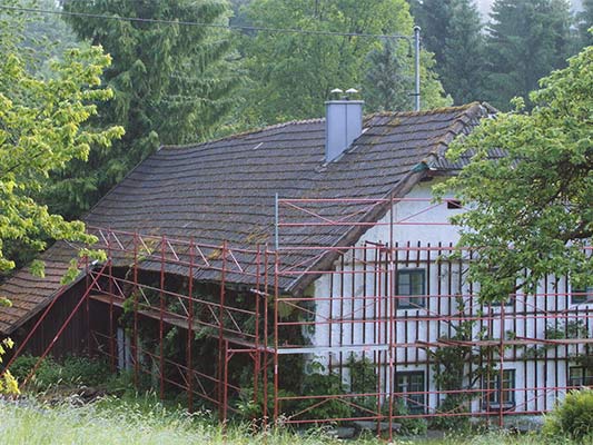 stary dach budynku Wiesenhaus przed remontem z użyciem dachówek łupkowych PREFA (z rusztowaniem).
