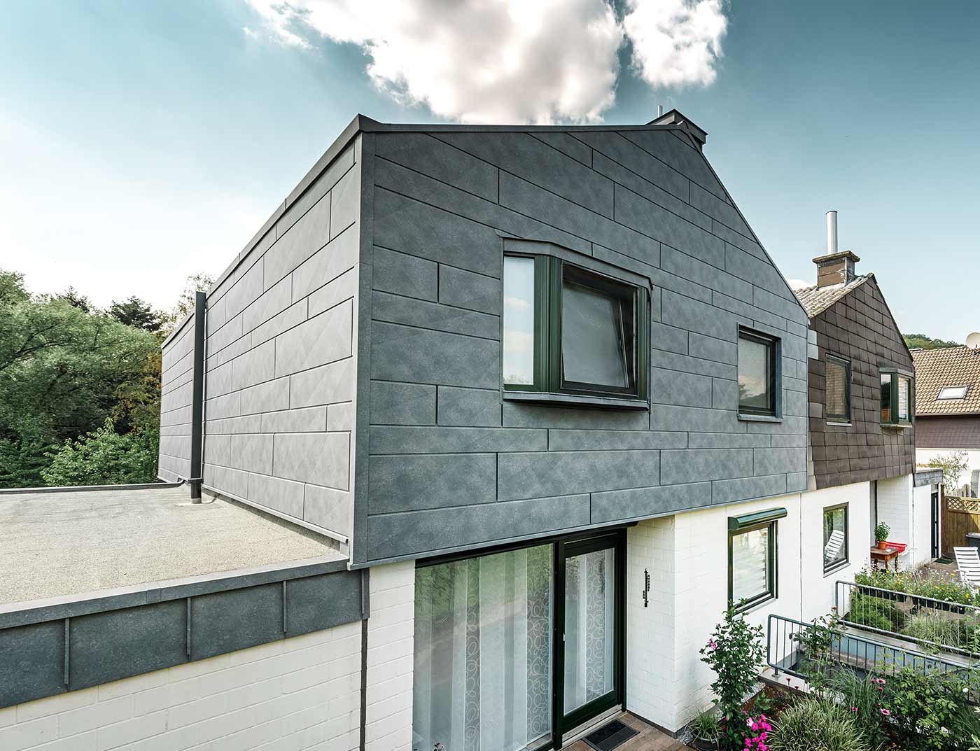 Modernizacja elewacji z nowym panelem elewacyjnym PREFA Siding.X w kolorze szarym kamiennym.